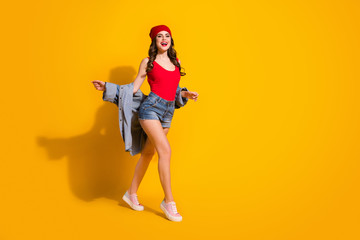Full length body size view of her she nice-looking attractive slender glamorous cheerful cheery wavy-haired girl walking having fun isolated over bright vivid shine vibrant yellow color background