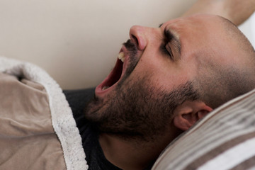 Obraz premium Caucasian bearded man wakes up and yawns 