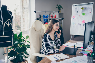 Profile side view portrait of nice attractive cheerful skilled seamstress needlewomen sitting in...