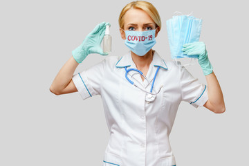 medical doctor nurse woman with stethoscope - holding protective mask and sanitizer