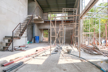 The 2 floors house under the construction has a steel ladder, scaffold and steel bar on the ground.