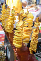Fried swirl potato spiral on a stick during street food festival.