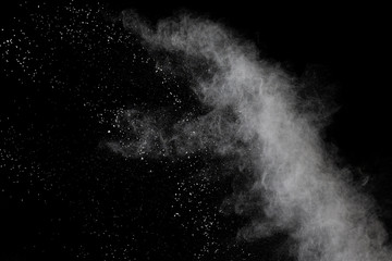 White powder explosion isolated on black background.White dust particles splash.