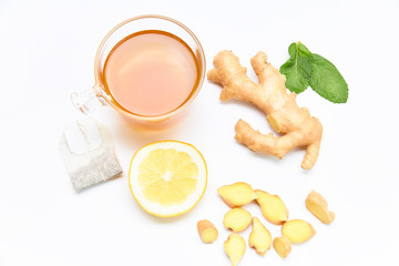 Hot cup of tea with lemon, ginger and mint leaves on a white background