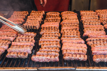 Chef preparing meat on the grill, during outdoor outside food festival, food truck