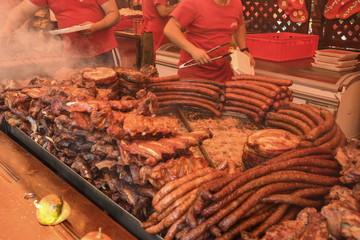 Chef preparing meat on the grill, during outdoor outside food festival, food truck