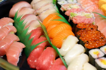 Overhead view of Japanese food sushi . several rolls with tuna, salmon and shrimp. Japanese delivery sushi set at home party.