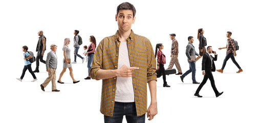 Fototapeta premium Confused young man pointing at a crowd of people walking in different directions