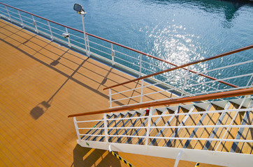 Empty staircase or stairs on cruiseship or cruise ship liner with metal railing and wooden handrail...