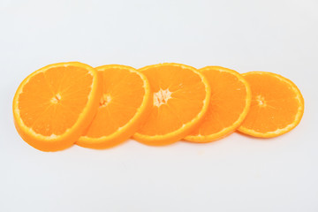 Thin sliced orange circles isolated on white background. Orange cutting as round pieces and ready for eating. Close-up side view. Citrus fruit, vitamin and healthy food concept
