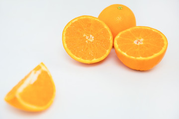 Composition with tasty juicy orange fruits. Quarter of orange laying separate and out-of-focus. Selective focus. Close-up side view. Citrus fruit, vitamin and healthy food concept