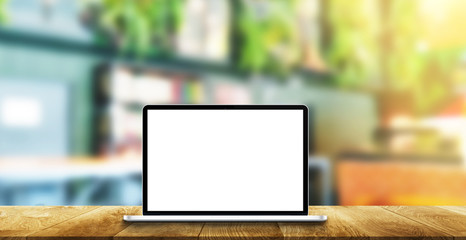 computer screen white on a wooden table and background coffee store blur.