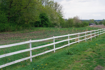 Fototapeta na wymiar white fence enclosing the forest 