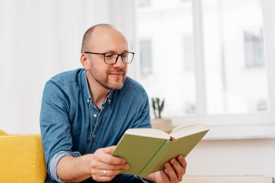 Middle-aged man sitting reading a book