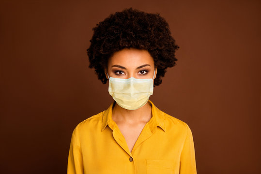 Closeup photo of beautiful pretty dark skin wavy lady good mood easy-going person wear yellow shirt blouse protection respiratory mask isolated brown color background