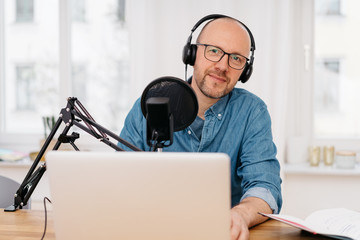 Man recording podcast looking at camera