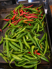 Green and red chili on a counter top of a store during food festival market.