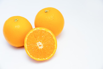 Two whole oranges and half of orange isolated on white background. Close-up side view. Citrus fruit and healthy food concept