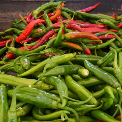 Green and red chili on a counter top of a store during food festival market.