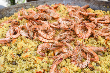 Seafood paella cooked in a large pan wok, street food festival. Mexican fiesta national day