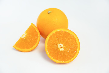 Composition of orange pieces and whole fruit laying isolated on white background. Close-up side view. Citrus fruit and healthy food concept