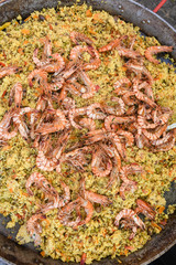 Seafood paella cooked in a large pan wok, street food festival. Mexican fiesta national day