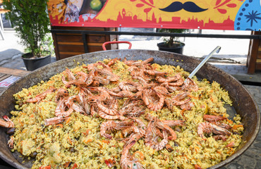 Seafood paella cooked in a large pan wok, street food festival. Mexican fiesta national day