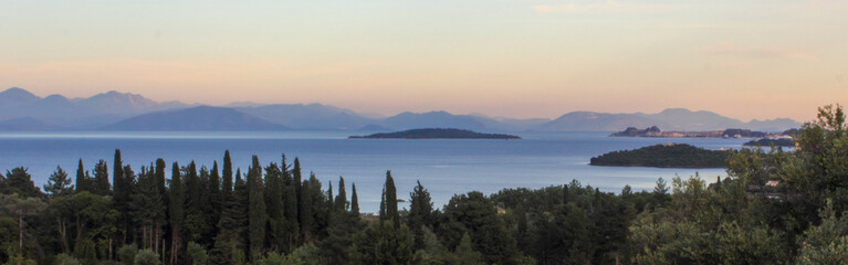 panoramic view of corfu town island mountains and sea with cypress and olive trees