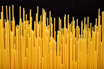 Raw spaghetti pasta on black background