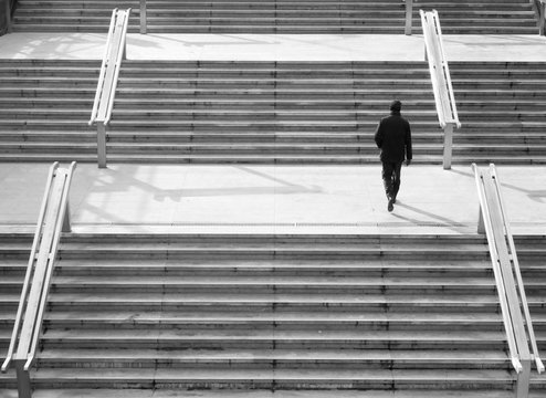 Man walking up a modern staircase in a city