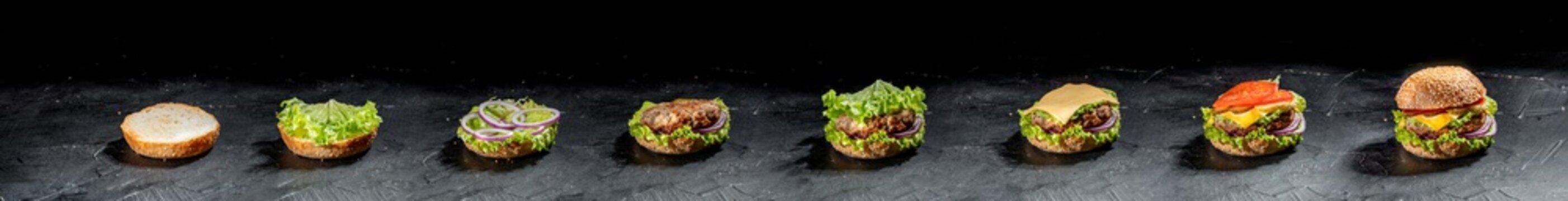 Delicious burger with cheese and vegetables on the dark background