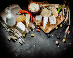 Different sorts of cheese. Сheese delicatessen on a black concrete background. Top view with copy space