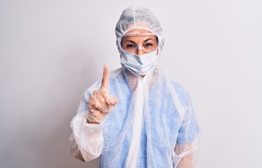 Middle age nurse woman wearing protection coronavirus equipment over white background showing and pointing up with finger number one while smiling confident and happy.