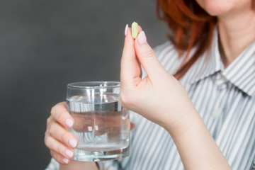 Girl holds a pill in her hand and prepares to take the drug
