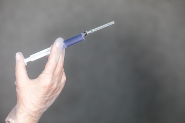 The nurse holds a syringe in her hand and prepares to give the patient an injection