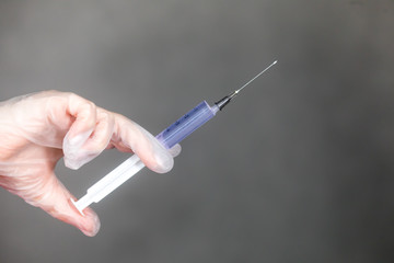 The nurse holds a syringe in her hand and prepares to give the patient an injection