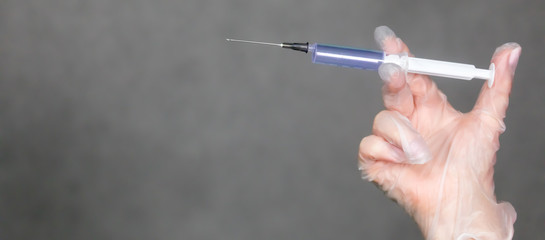 The nurse holds a syringe in her hand and prepares to give the patient an injection