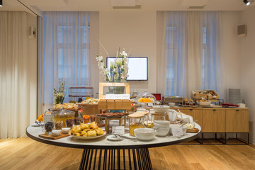 Breakfast served on round buffet table in hotel restaurant
