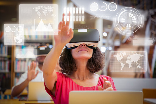 Adult students using VR simulators for virtual statistics for studying. Man and woman in virtual reality glasses sitting at desks with laptops and touching air. VR simulation concept