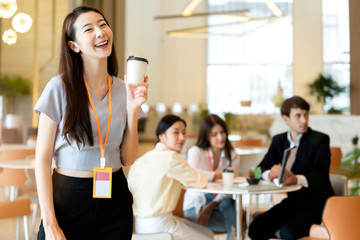 portrait Asian business people standing with confident and cheerful with business teamwork meeting brainstorm with laptop and paper document modern office background