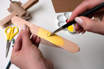 How to make airplane. Hand made toy,zero waste from toilet paper roll and popsicle sticks. For kids and parents.Step 9, wings details paint in yellow.