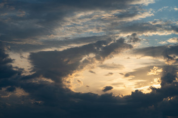 Blau-graue Wolkenberge hemmen dramatisch die Sicht auf den hellen Sonnenuntergang am Abend