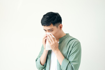 man is sick and sneezing with white background, asian