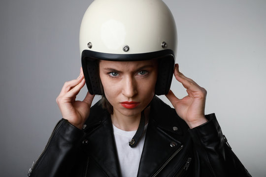 Headshot portrait of attractive biker woman wearing white helmet and shows safety conditions. Space for text.