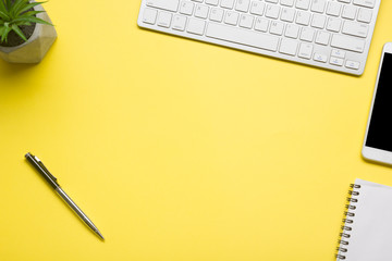 Yellow desk office with laptop, smartphone and other work supplies with cup of coffee. Top view with copy space for input the text. Designer workspace on desk table essential elements on flat lay