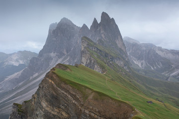 Obraz premium Dramatic weather with rain clouds at mountain peaks and steep cliffs of Seceda in the European Dolomite Alps, South Tyrol Italy.