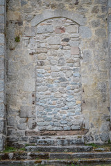 Ancient blocked door at the fortified monastery of Saint-Michel des Anges at Saint-Angel, France.