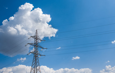Obraz premium Electricity transmission power lines (High voltage tower) high-voltage lines. Transmission of electricity by means of supports through agricultural areas sunny day with cirrus clouds in the blue sky