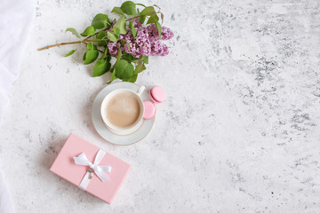 Fototapeta na wymiar flat lay coffee Cup a sprig of lilac and a gift pink box. Good morning background, place for text