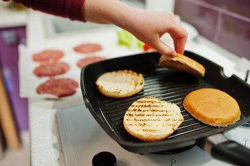 Сooking burgers in the kitchen at home during quarantine time.